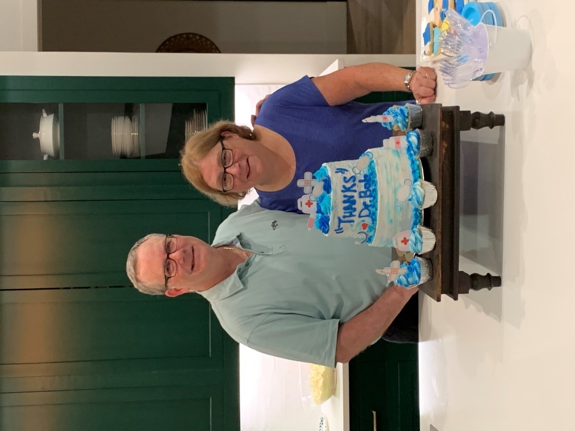 Dr. Robert Brodell and his wife Dr. Linda Brodell pose with a birthday cake